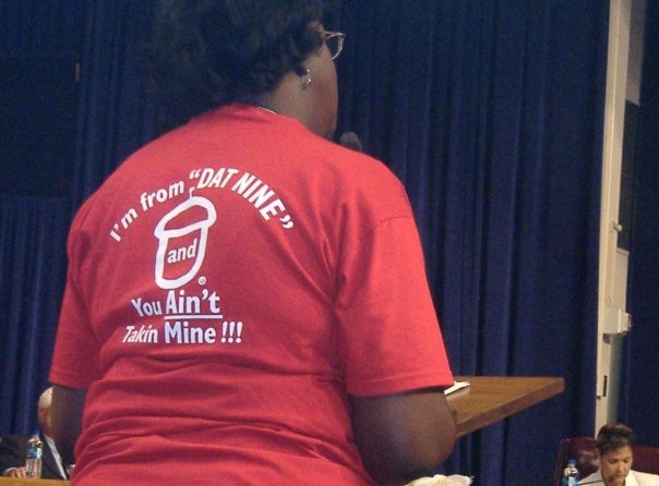 Photograph of an ACORN New Orleans member/leader wearing a red T-shirt that says, “I’m from ‘DAT NINE’ and you Ain’t Takin Mine!!!” (photo credit: Tanya Harris-Glasow or Marie Hurt).