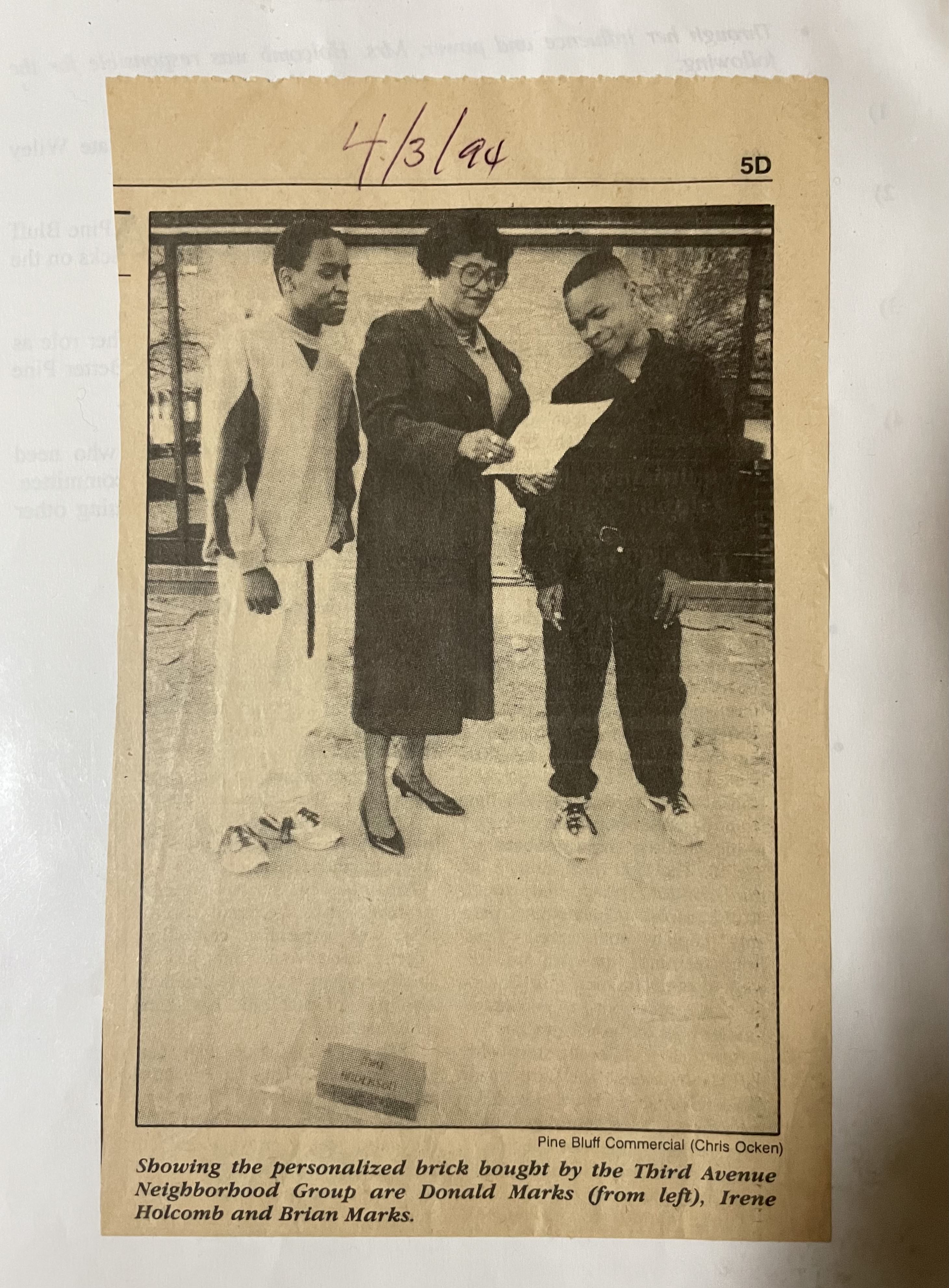Newspaper clipping from the Pine Bluff Commericial on April 3, 1994 featuring Irene Holcomb and two young men, Donald and Brian Marks, who, according to the caption, are showing the personzliaed brick bought by the Third Avenue Neighborhood Group.